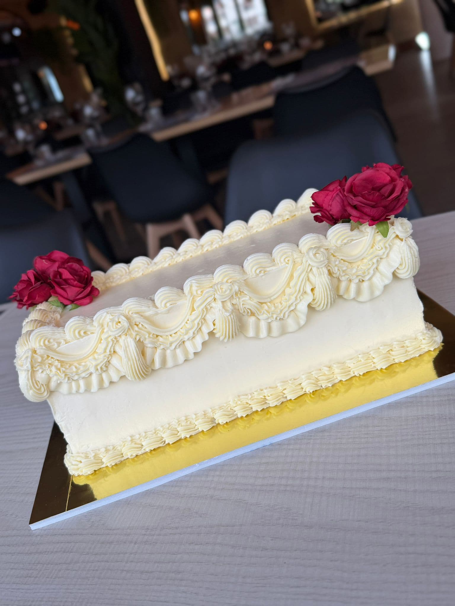 Tarta rectangular blanca decorada con rosas rojas