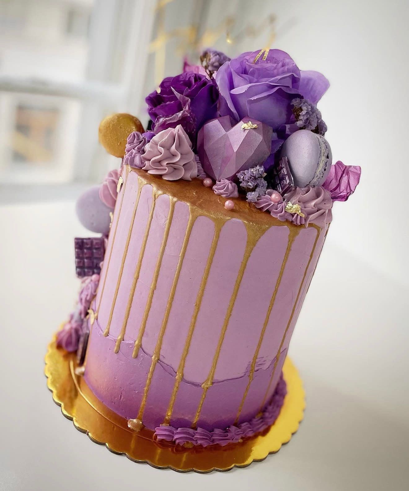 Tarta lila con drip dorado y flores moradas