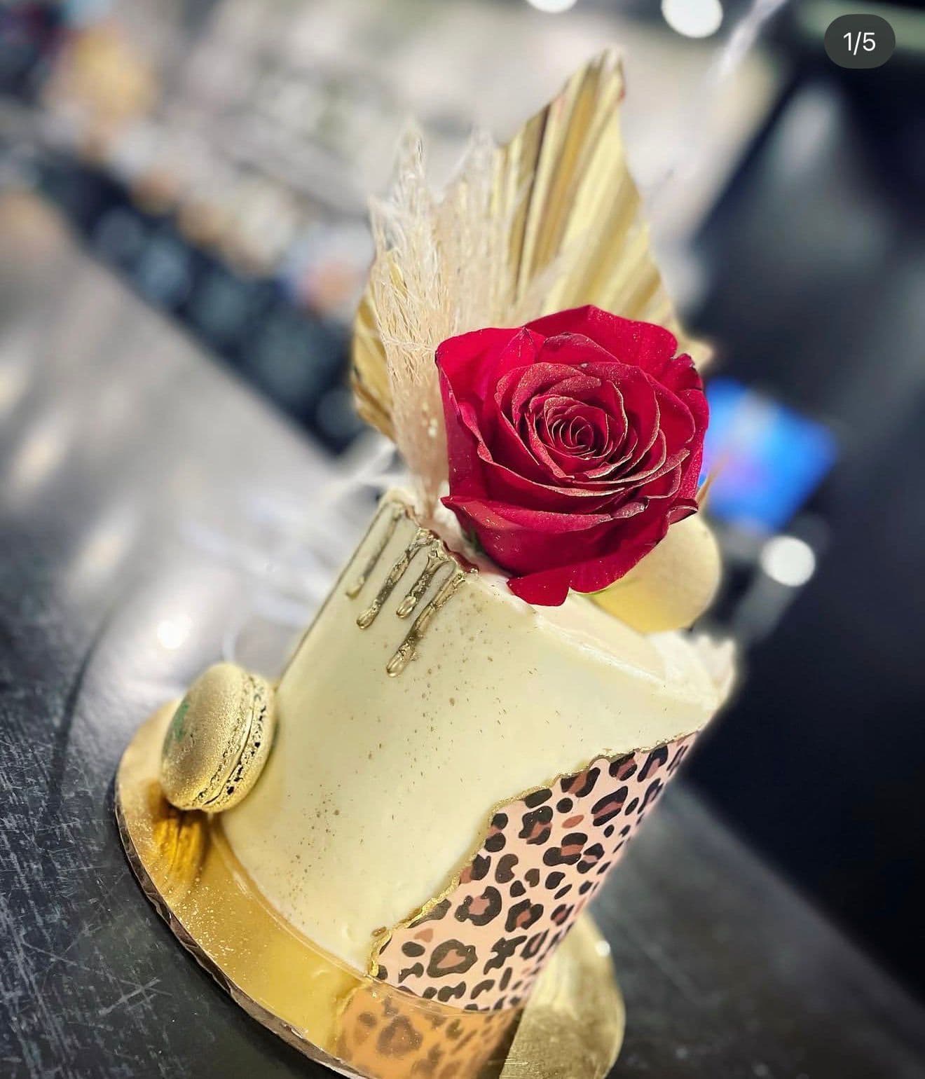 Tarta elegante blanca con rosa roja y detalles dorados